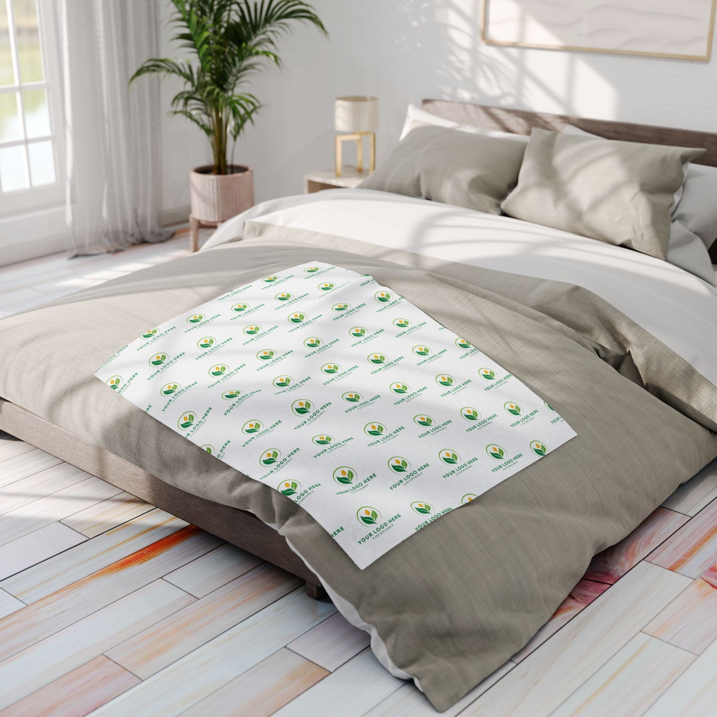 Bedding set with a branded pattern on a bed in a bright bedroom.
