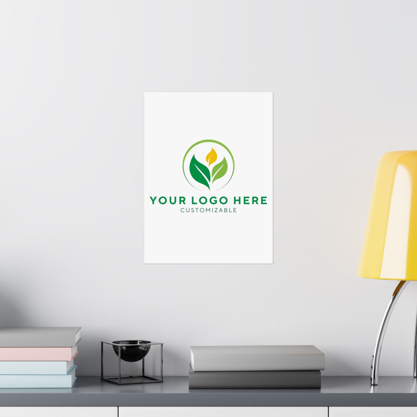 Customizable logo design on a white wall above a desk with books and a lamp.