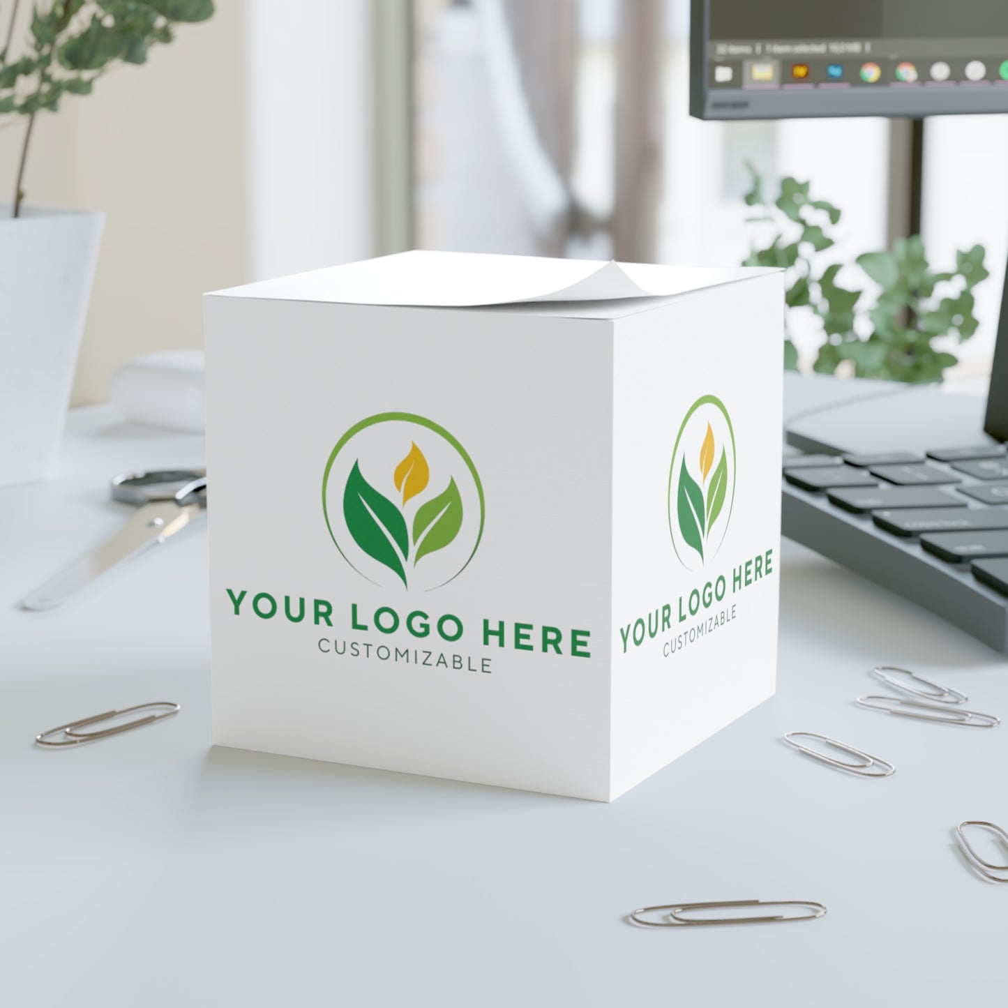 White cube with customizable logo on a desk with office supplies