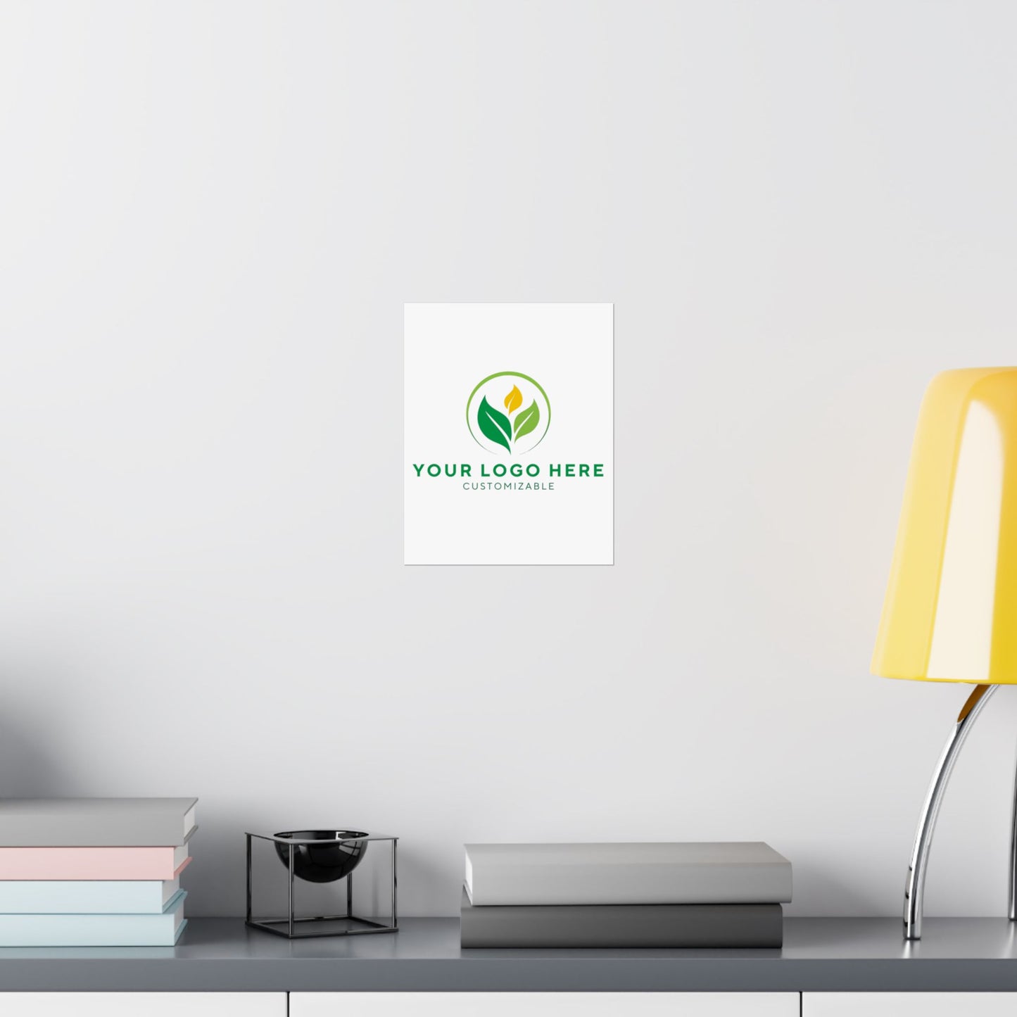 White wall with a customizable logo displayed on it, next to books and a lamp.