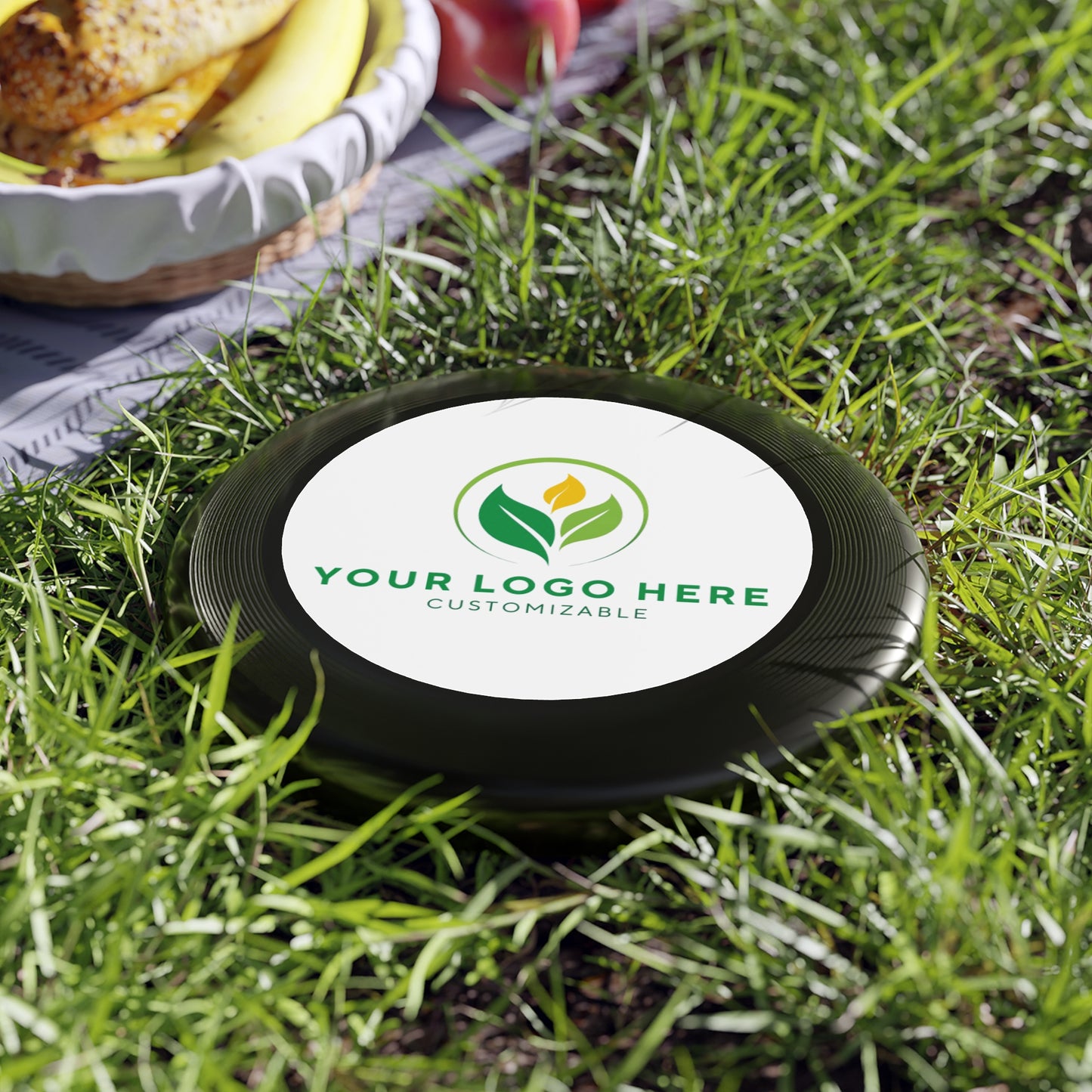 Customizable disc with a logo on grass, ready for branding.