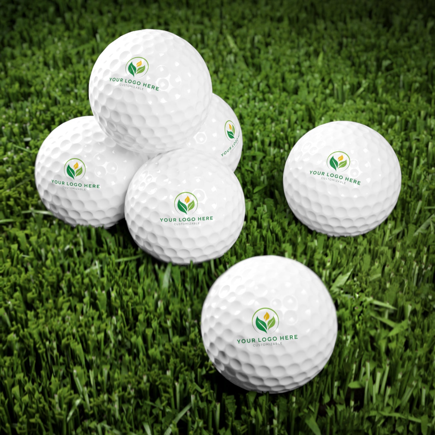 White golf balls with a logo on a grass background