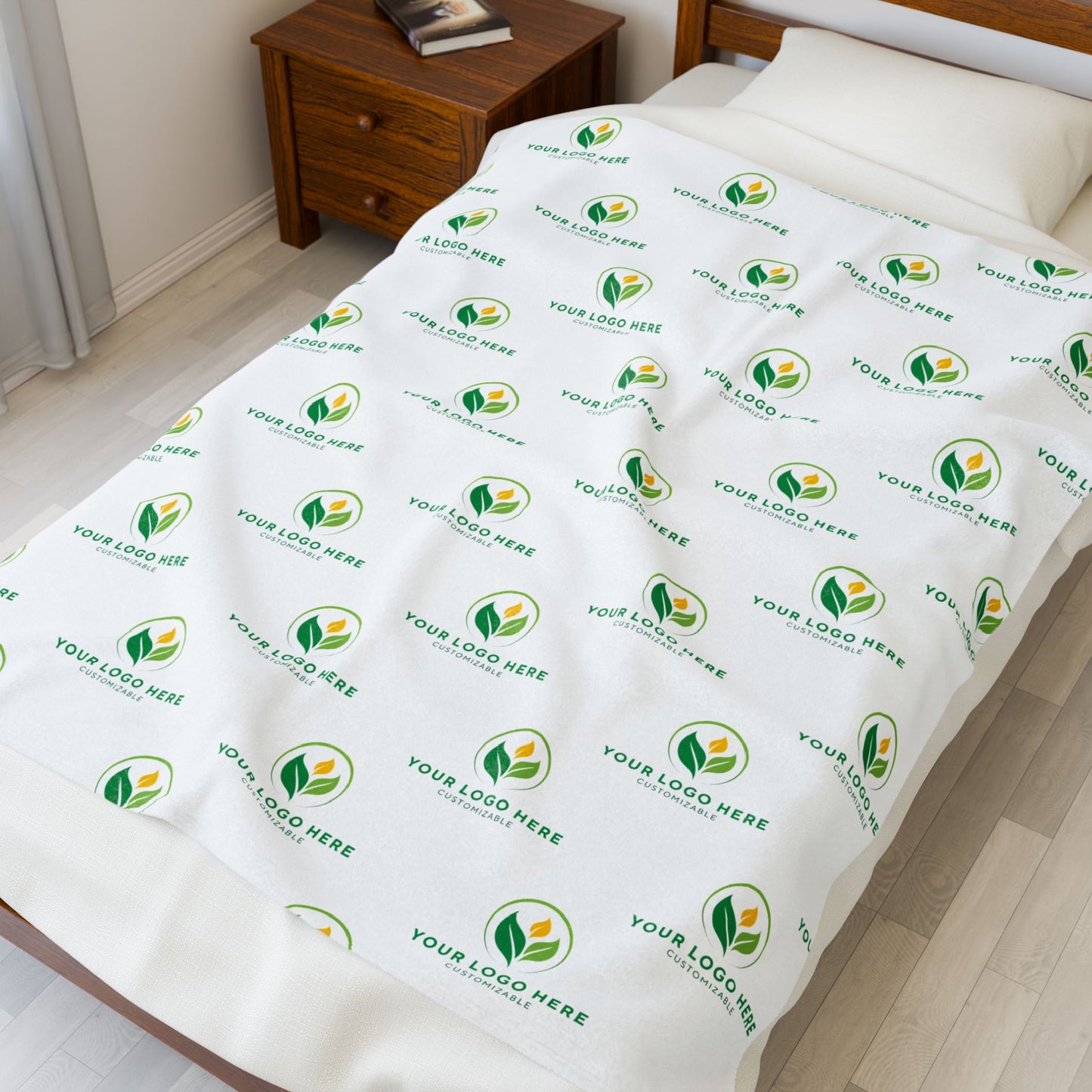 Bedding set with a branded pattern on a bed in a room.