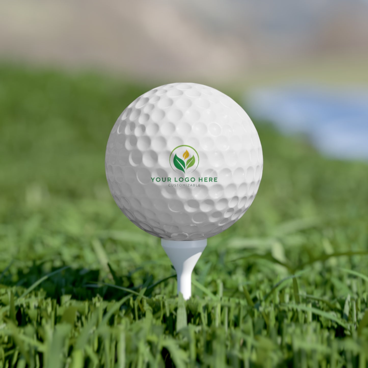Golf ball with a logo on a tee in grass