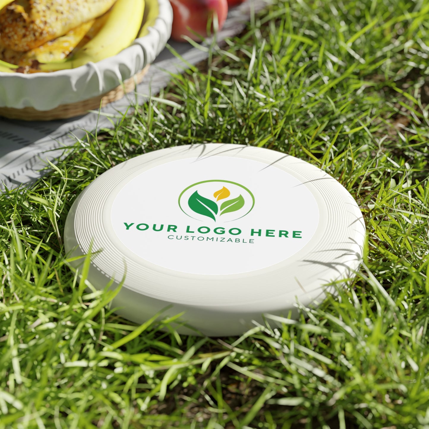 White frisbee with customizable logo on grass
