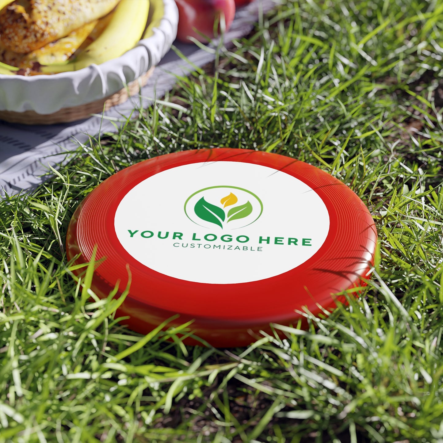 Red frisbee with customizable logo on grass