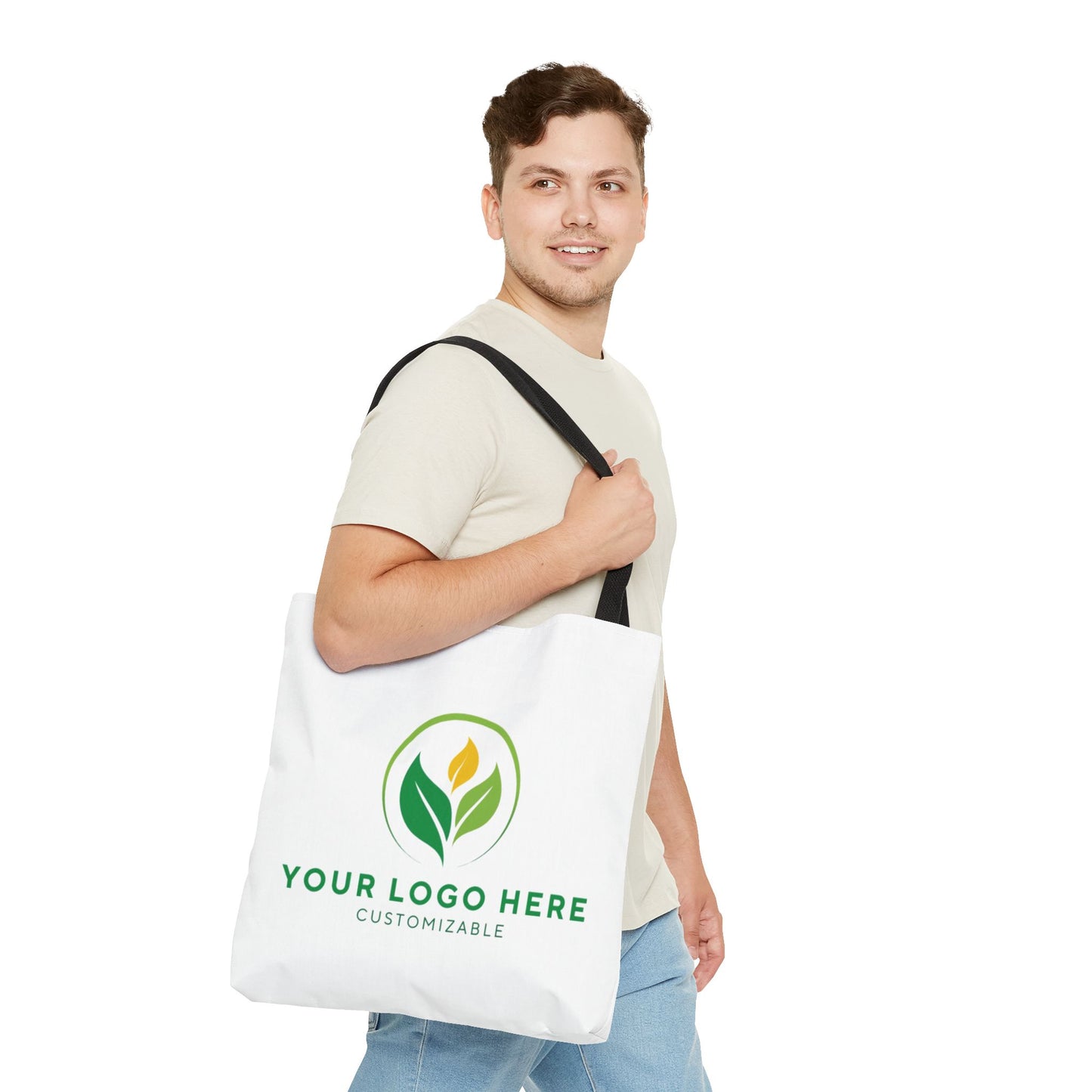 Man holding a customizable tote bag with a logo placeholder on a white background
