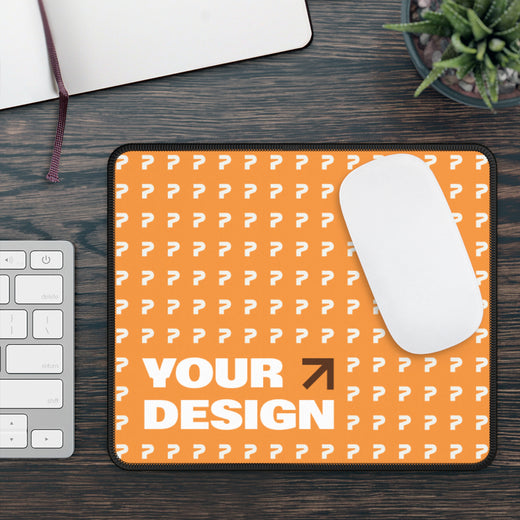 Orange mouse pad with white pattern and 'Your Design' text on a wooden desk with a keyboard and mouse.
