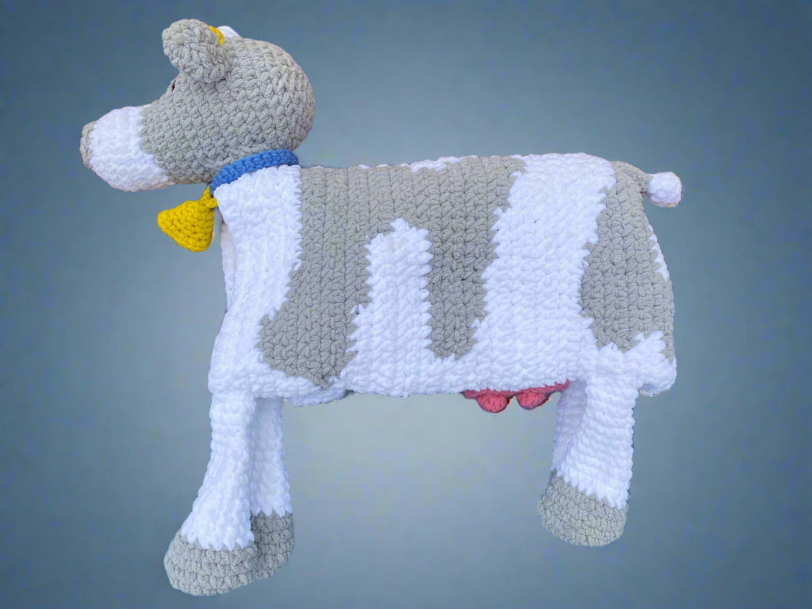 right view of gray and white crochet cow on gray background.