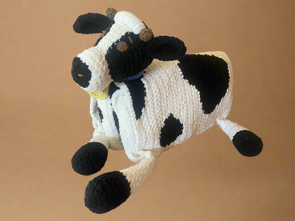crochet cow toy on a beige surface