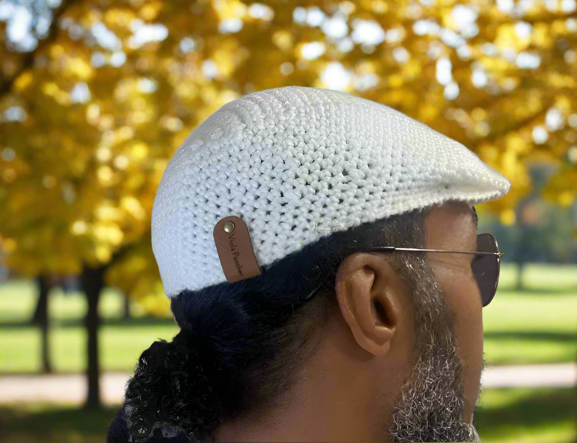 man wearing white crochet newsboy cap