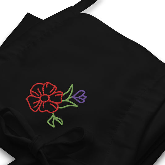 Close up of Black apron with floral embroidery on chest.