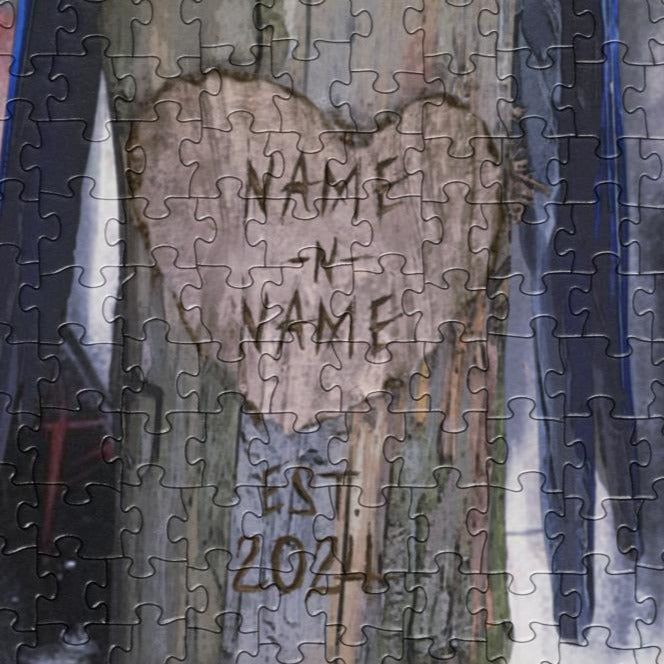Close up of a jigsaw puzzle depicting two blue hyacinth macaws perched on a wooden stump with a custom name label, surrounded by a blurred background.
