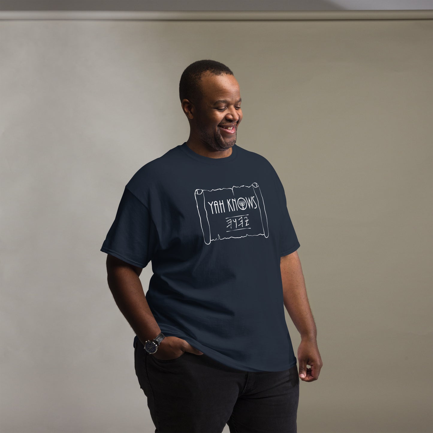 A person wearing a blue unisex crew neck t-shirt with the text 'YAH Knows' printed in white on the front.