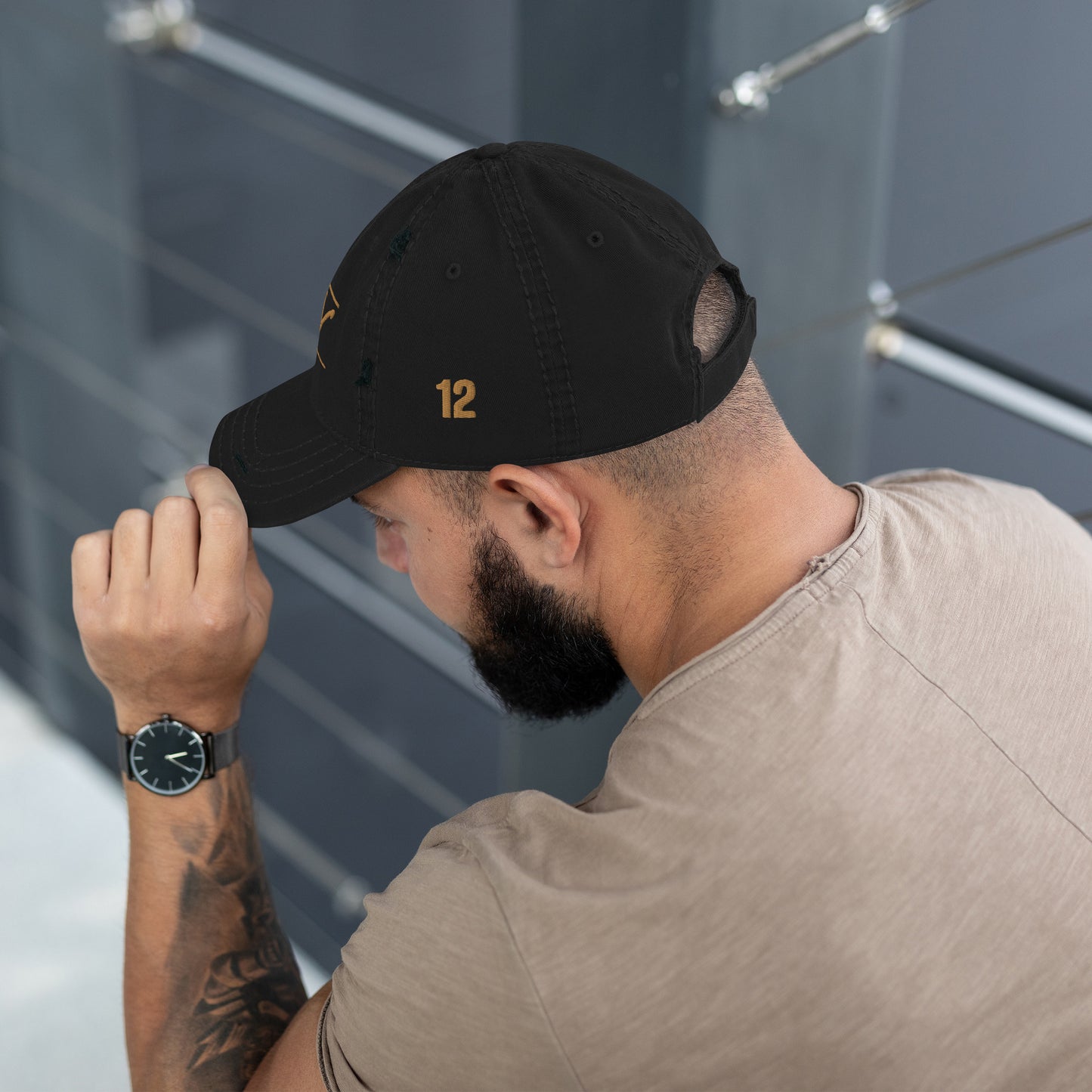 man wearing Distressed dad hat in black, khaki, navy, or charcoal featuring 'Yahuah' in Paleo‑Hebrew embroidered across the front in contrasting thread, with adjustable strap and worn‑in style, showing off the 12 embordered on its side.