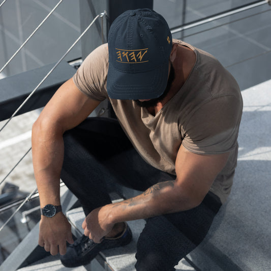 Distressed dad hat in black, khaki, navy, or charcoal featuring 'Yahuah' in Paleo‑Hebrew embroidered across the front in contrasting thread, with adjustable strap and worn‑in style.