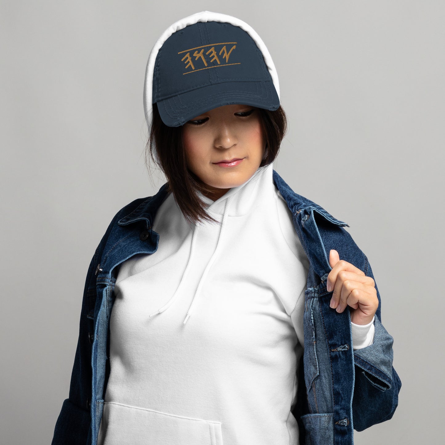woman wearing Distressed dad hat in black, khaki, navy, or charcoal featuring 'Yahuah' in Paleo‑Hebrew embroidered across the front in contrasting thread, with adjustable strap and worn‑in style.