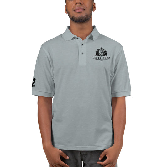 Men’s Premium Polo Leftykeyz Edition in stone—relaxed cotton-poly pique, embroidered Leftykeyz logo on chest, flat knit collar, metal buttons, side vents.
