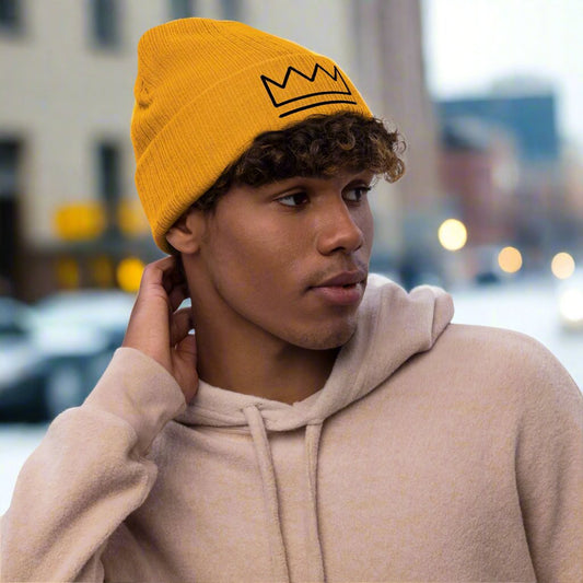 Crown ribbed knit beanie in mustard, light grey melange, beige, or acid green, featuring a minimalist embroidered crown icon on the folded cuff. Double-layer recycled polyester/acrylic knit, one-size-fits-most.
