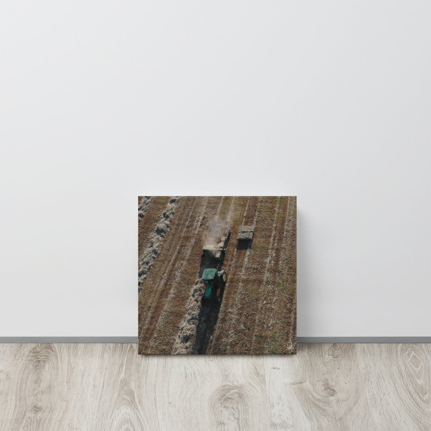 A canvas painting featuring a tractor in a field, with a visible green and brown color palette.