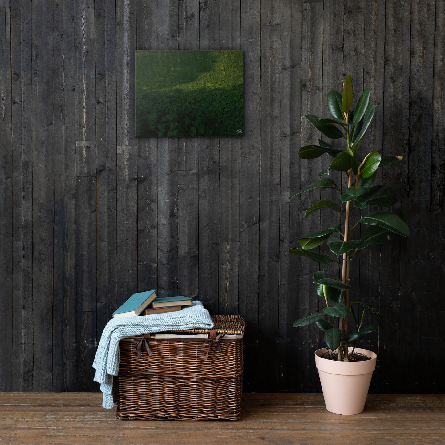 A canvas painting featuring a green and brown landscape, thin and with built-in wall mounts.