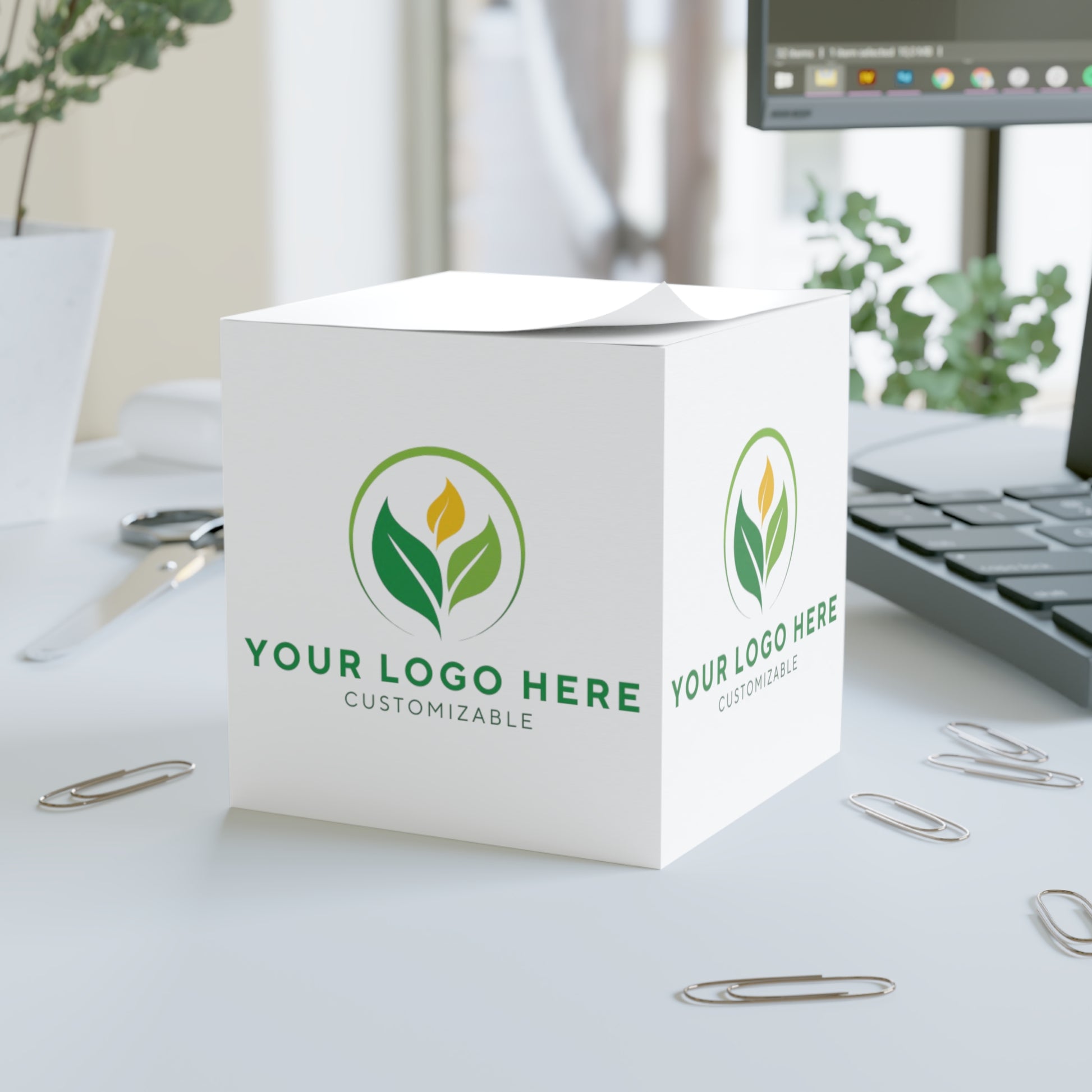 White cube with customizable logo on a desk with office supplies