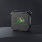 Black portable speaker with a logo on a dark background