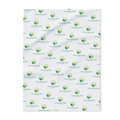 Patterned blanket with green and yellow logo repeats on a white background