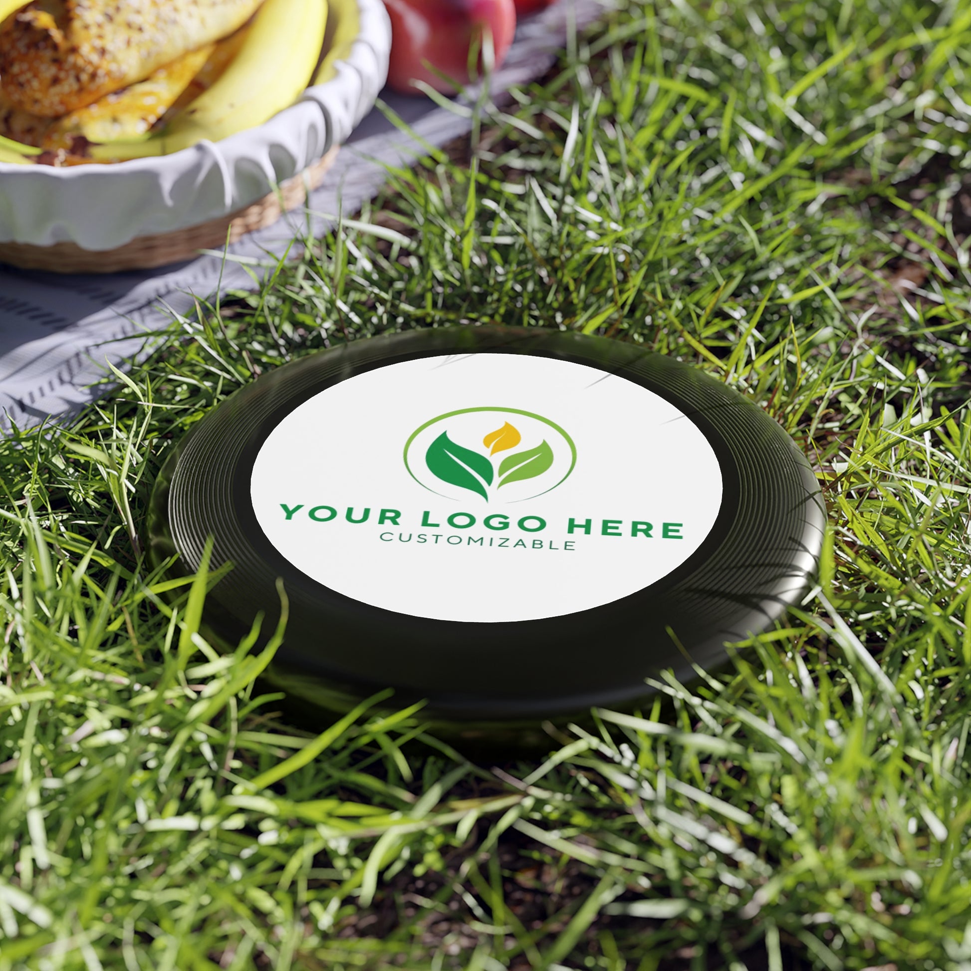 Customizable disc with a logo on grass, ready for branding.