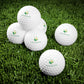 White golf balls with a logo on a grass background