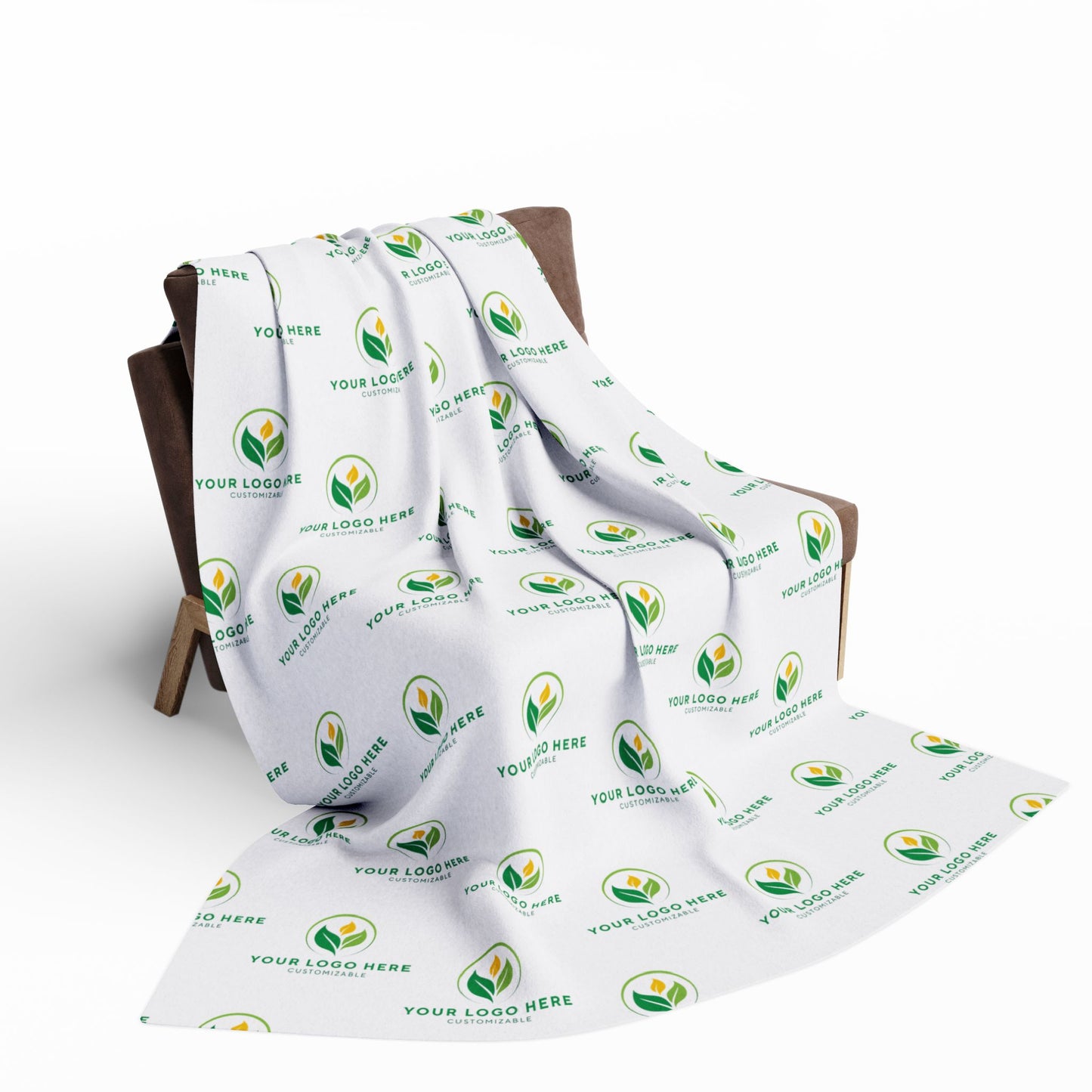 White blanket with green leaf logo and text on a wooden chair against a white background