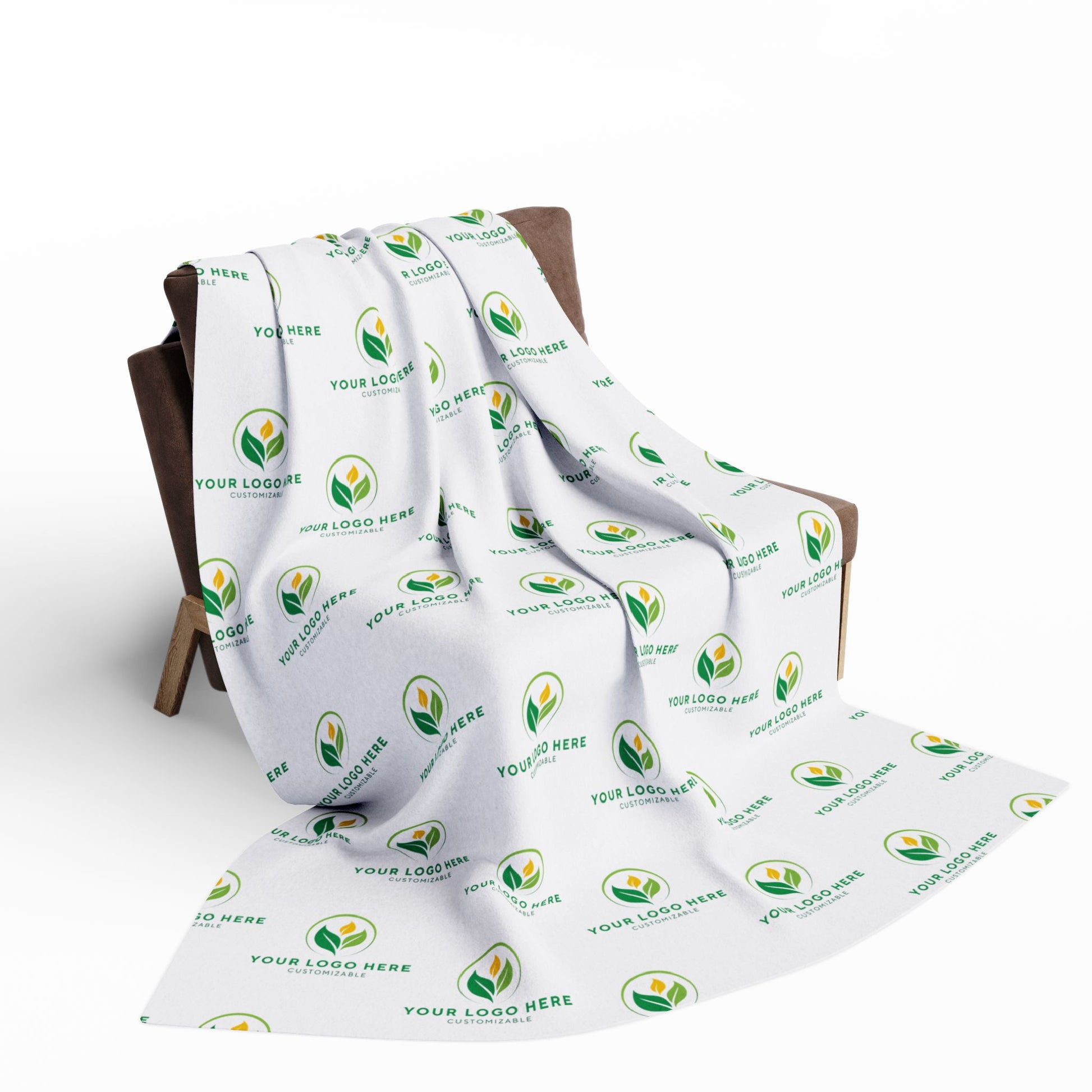 White blanket with green leaf logo and text on a wooden chair against a white background