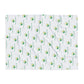 White blanket with green and yellow logo pattern on a white background