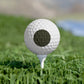 Golf ball on a tee in grass with a blurred background