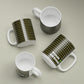 Four white customizable mugs with black patterned designs on a beige background