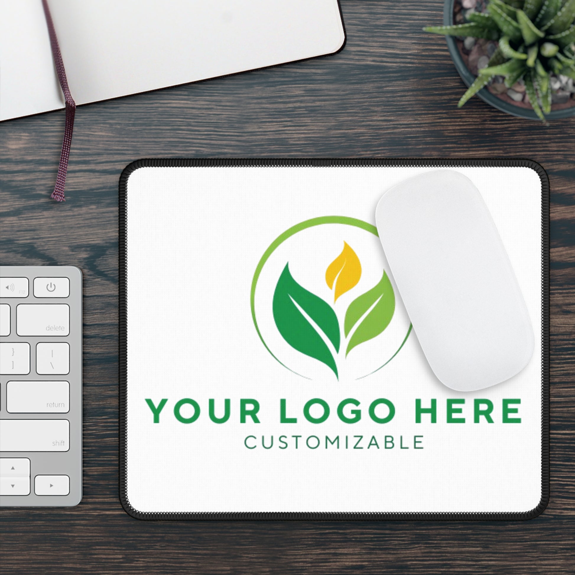 Customizable mouse pad with a leaf logo on a wooden desk.