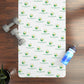 Personalized yoga mat with brand logo, dumbbells, and water bottle on a wooden floor.