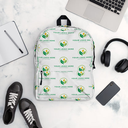 White backpack with green logo pattern on a white surface with accessories.