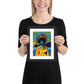 Person holding a framed colorful artwork of a person with an afro on a white background