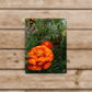 A canvas painting featuring a close-up image of an orange flower with a green background.