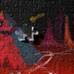 close up of Assorted jigsaw puzzle pieces with a vibrant image of a dragon or a similar creature in a dark, red-colored background. The puzzle depicts a scene with what appears to be a supernatural or fantastical creature.